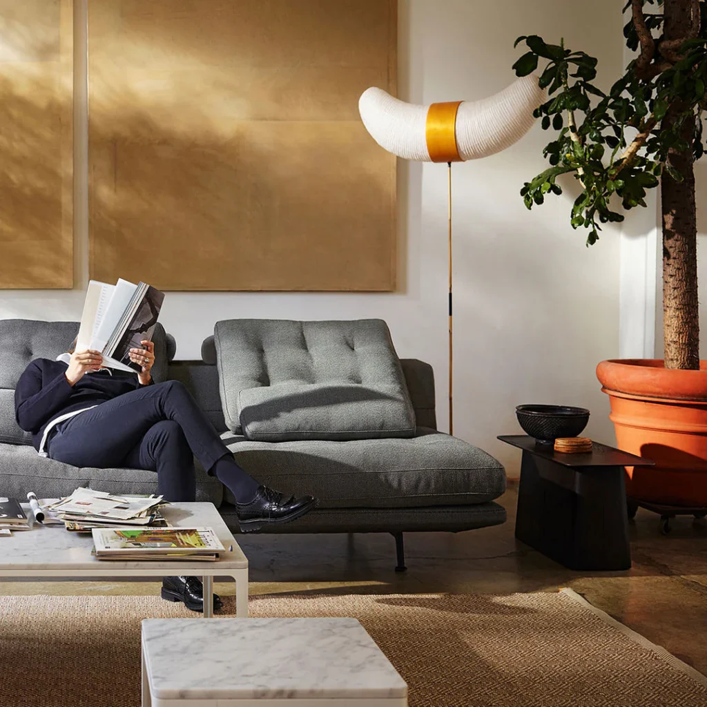 Person reading on modern sofa.